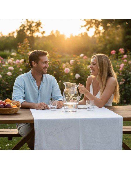 Pareja disfrutando de una cena con jarra de cristal grabada artísticamente con Gravo Stick.