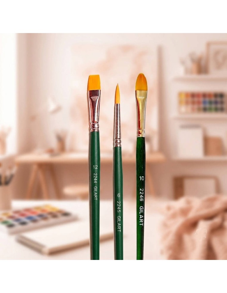 Set de pinceles variados Gilart de pelo sintético Toray sobre fondo artístico desenfocado de estudio de arte