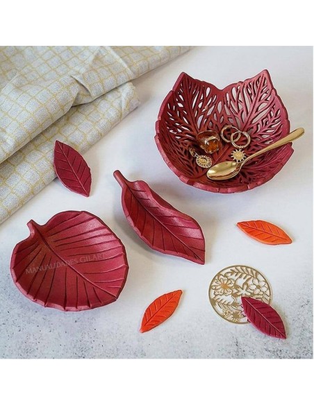 Bandejas decorativas con forma de hoja pintadas tras el secado de la arcilla roja.