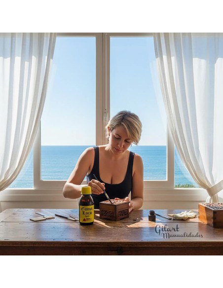 Artesana aplica Goma Laca Líquida Promade para un acabado brillante, junto al mar